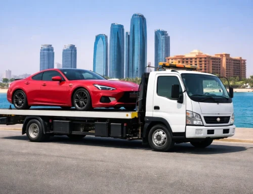 Flatbed car towing service in Abu Dhabi transporting a red car safely